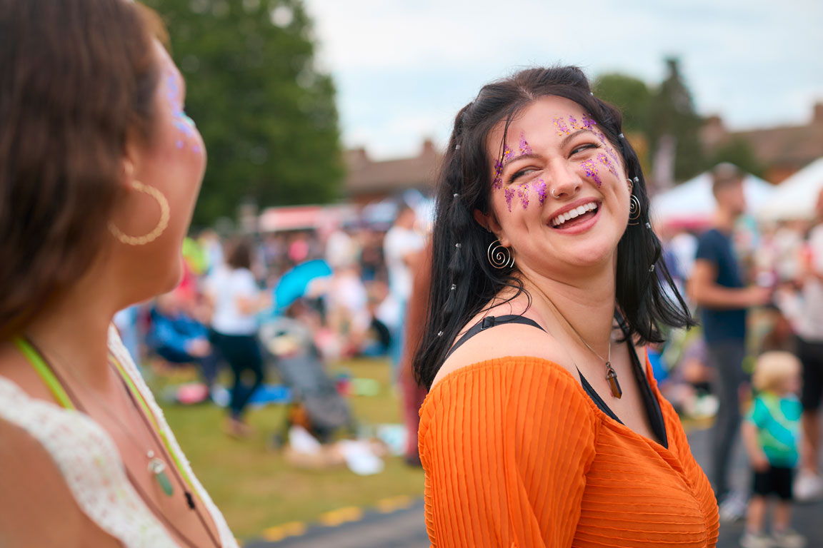 two-female-friends-wearing-glitter-having-fun two female employees attending outdoor corporate event