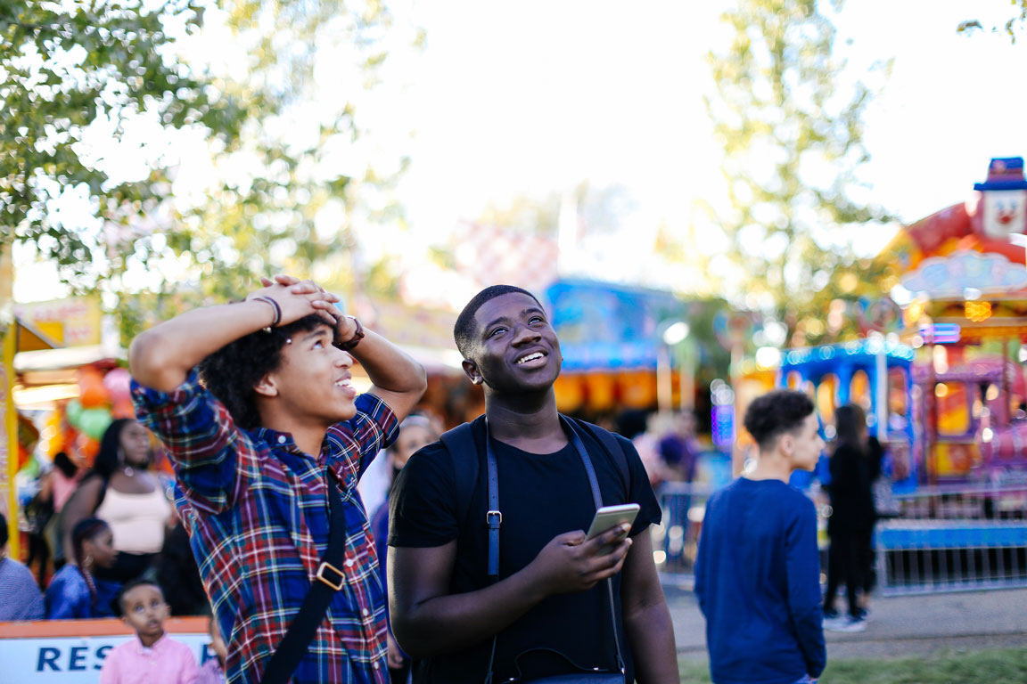 two-friends-at-funfair-looking-up-laughing school carnival
