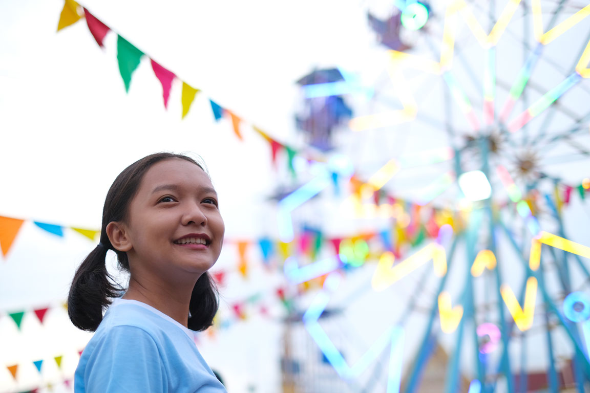 happy-young-girl-at-the-amusement-park woman in front of Ferris wheel